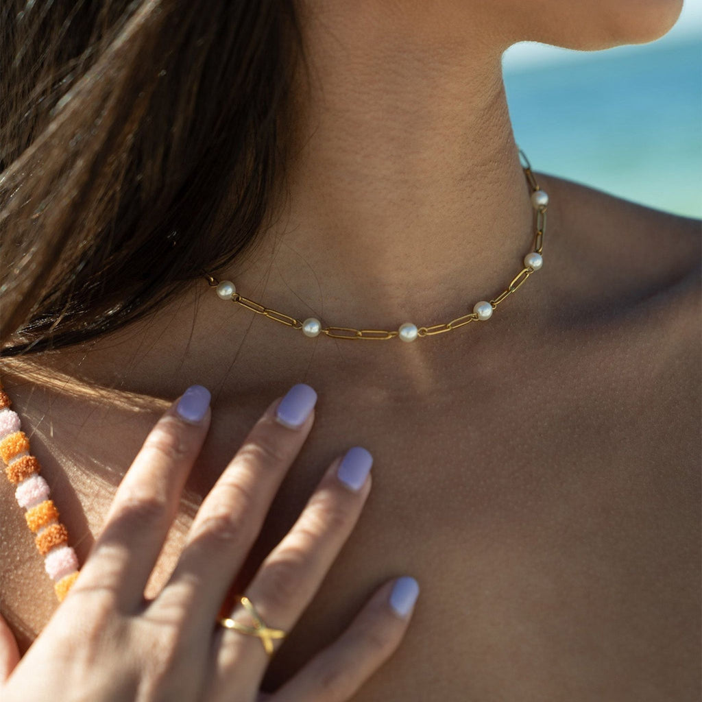 Pearl necklace worn by a person with a blurred background