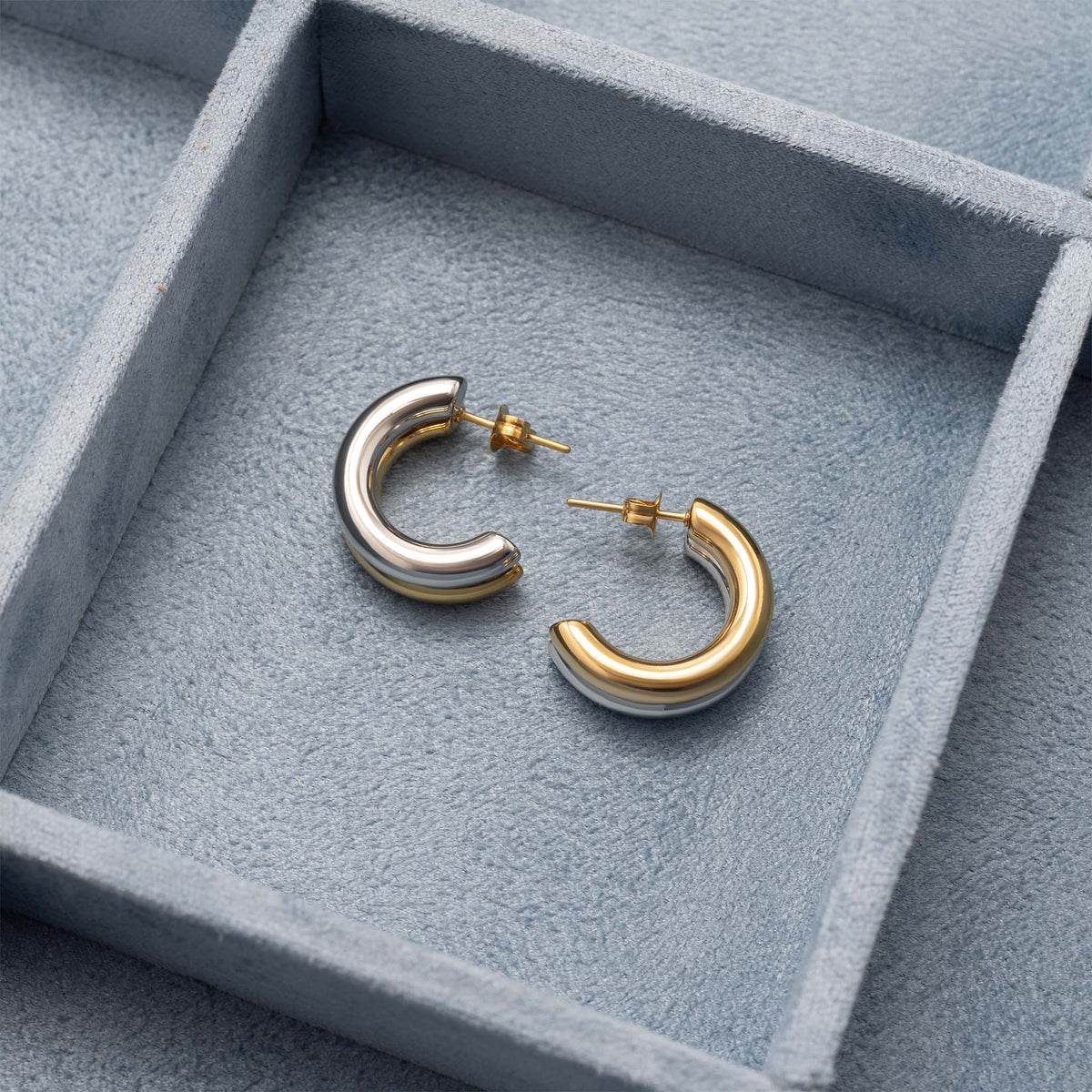 Mixed metal side-by-side huggie earrings close-up