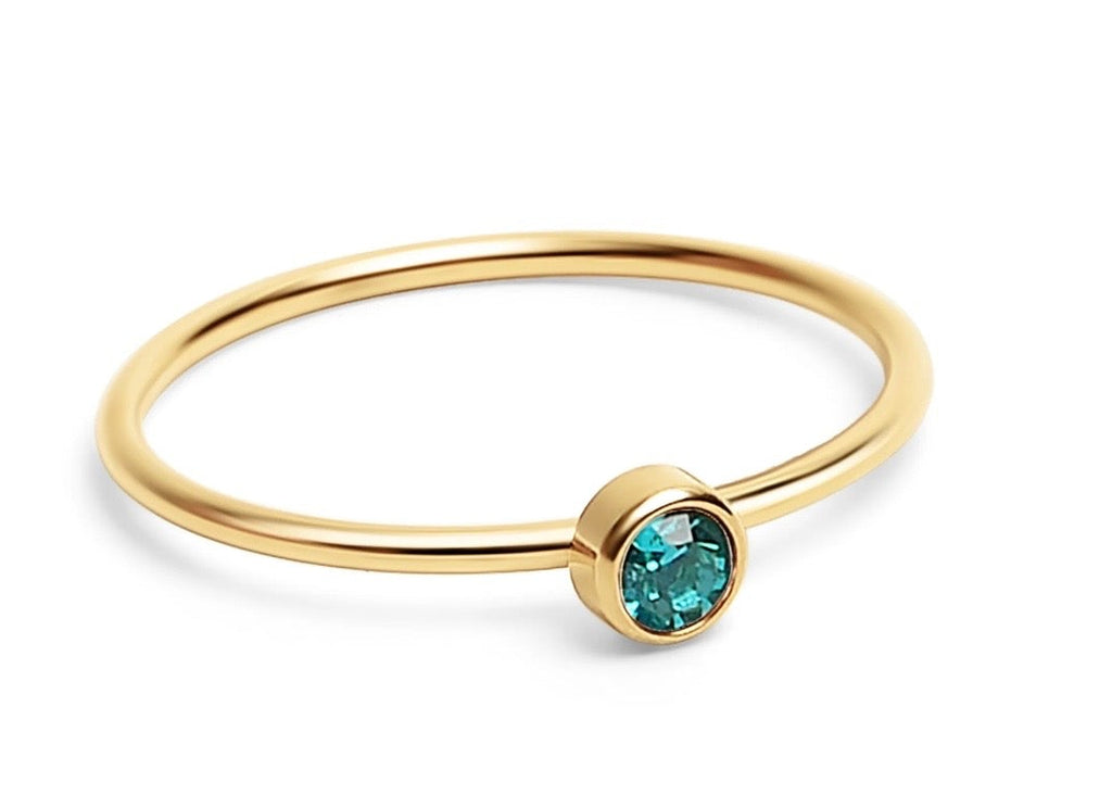A delicate gold bangle ring featuring a bezel-set round turquoise gemstone, shown on a clean white background.