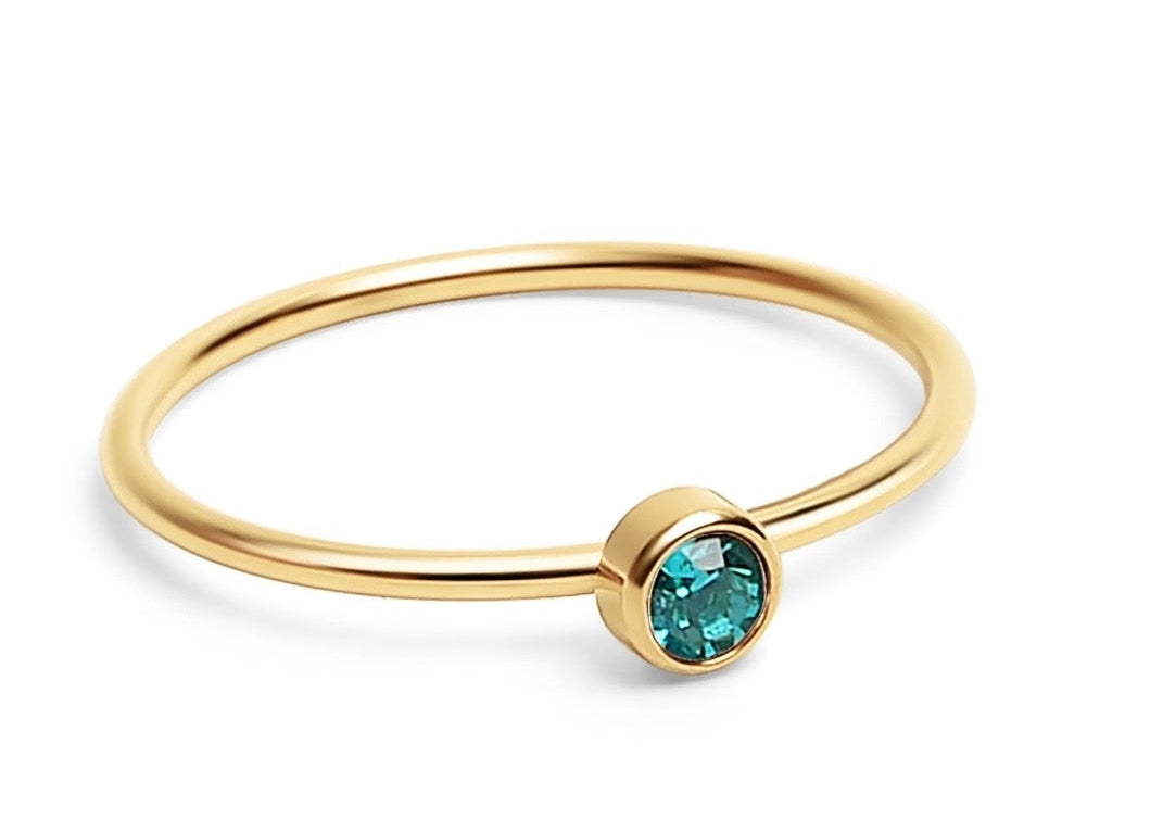 A delicate gold bangle ring featuring a bezel-set round turquoise gemstone, shown on a clean white background.