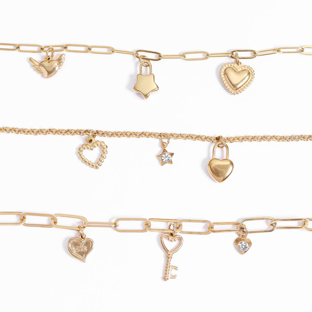 Set of gold charm bracelets on a white background