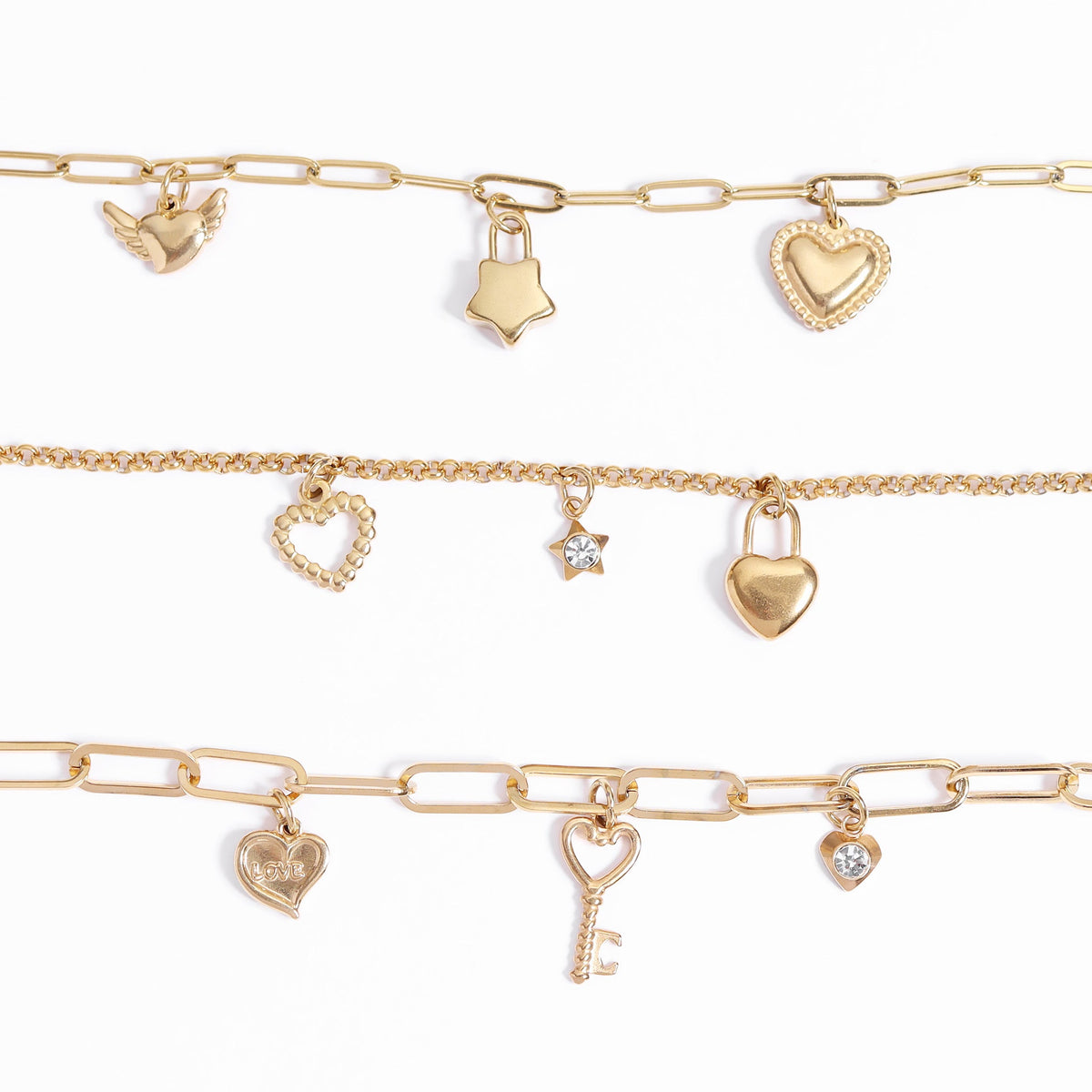 Set of gold charm bracelets on a white background