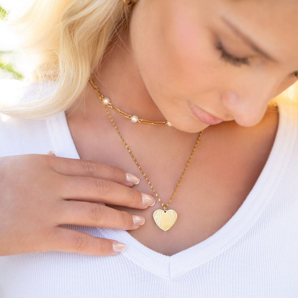 Woman wearing a gold necklace with a heart pendant