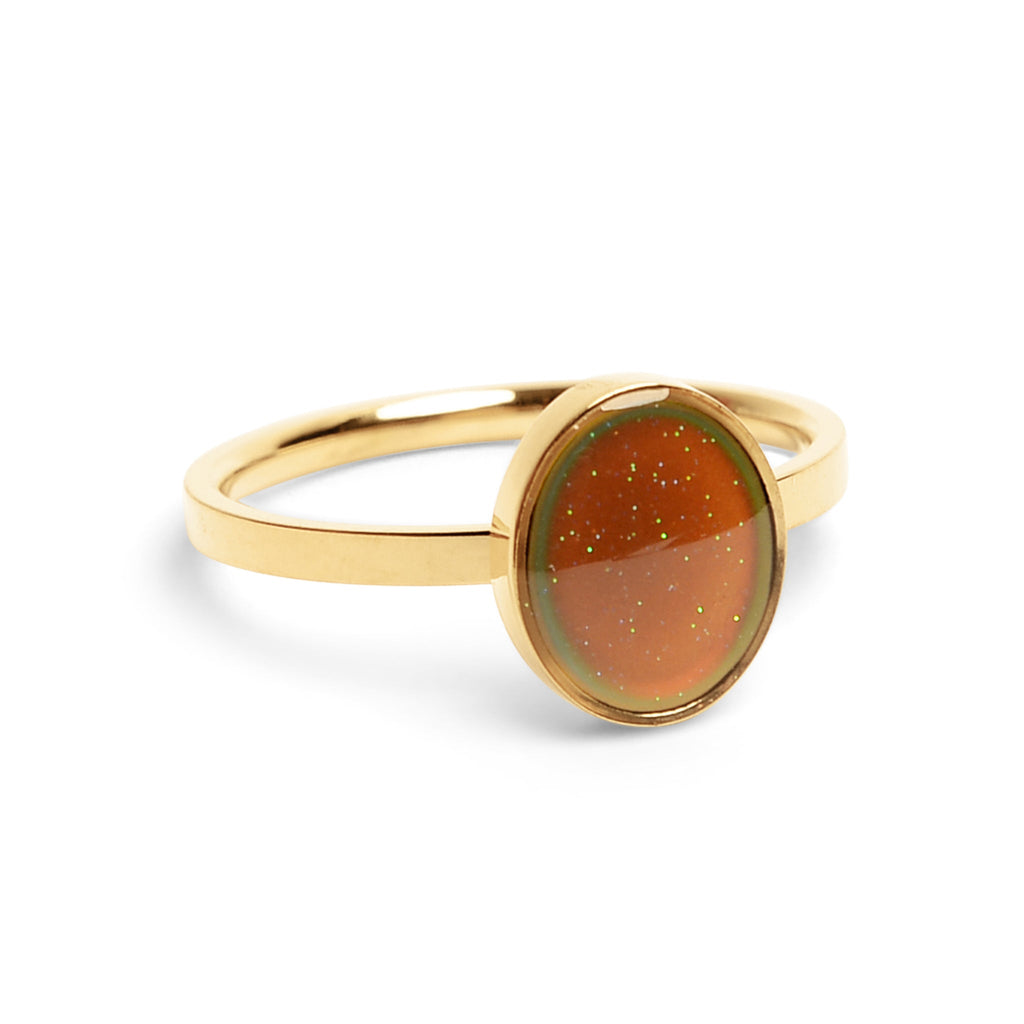 Gold mood ring with a brown gemstone on a white background
