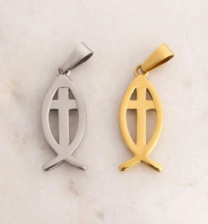 Two fish-shaped pendant charms with a cross cutout, shown side by side on a light marble background. One is silver-toned and the other is gold-toned.