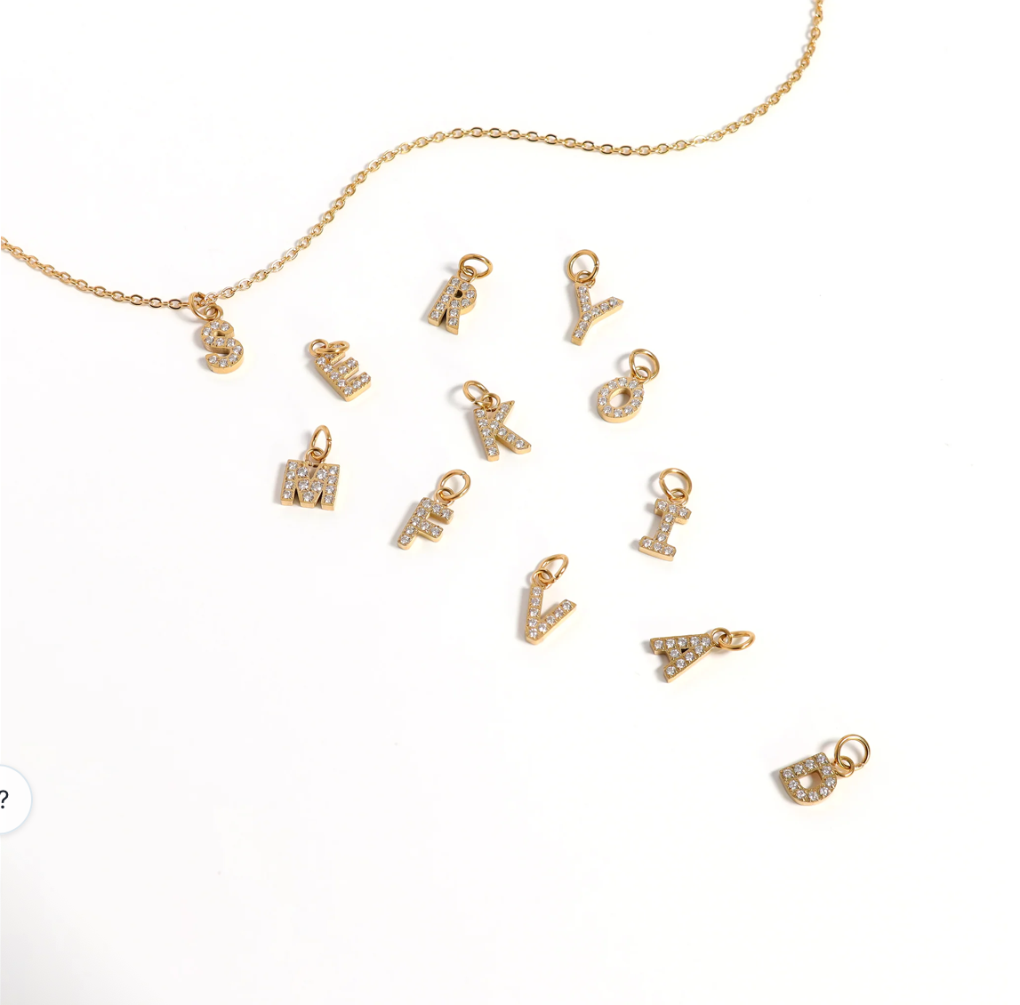Initial letter charm attached to a necklace chain