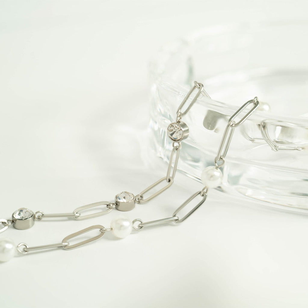Silver chain bracelets with pearls on a white background