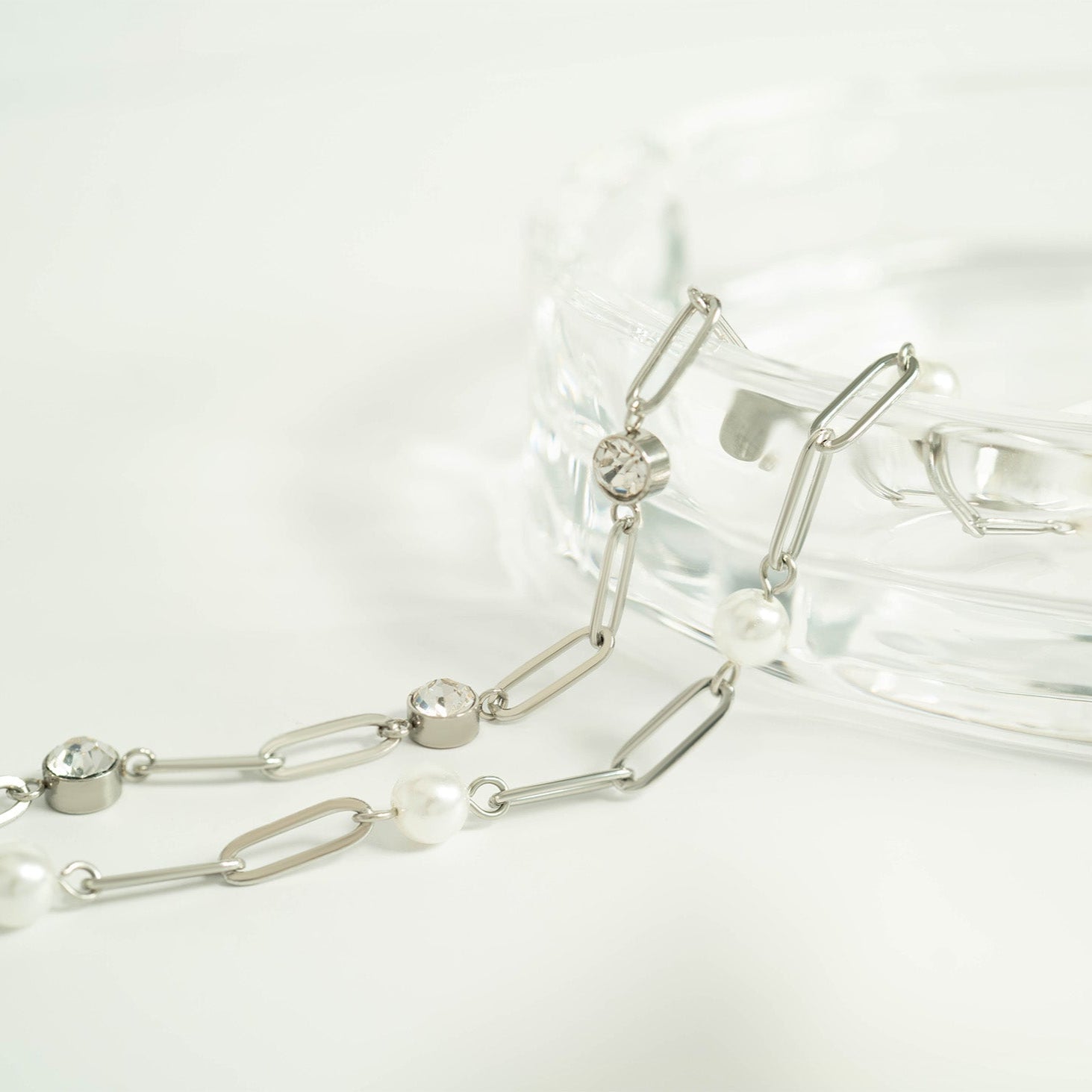 Silver chain bracelets with pearls on a white background