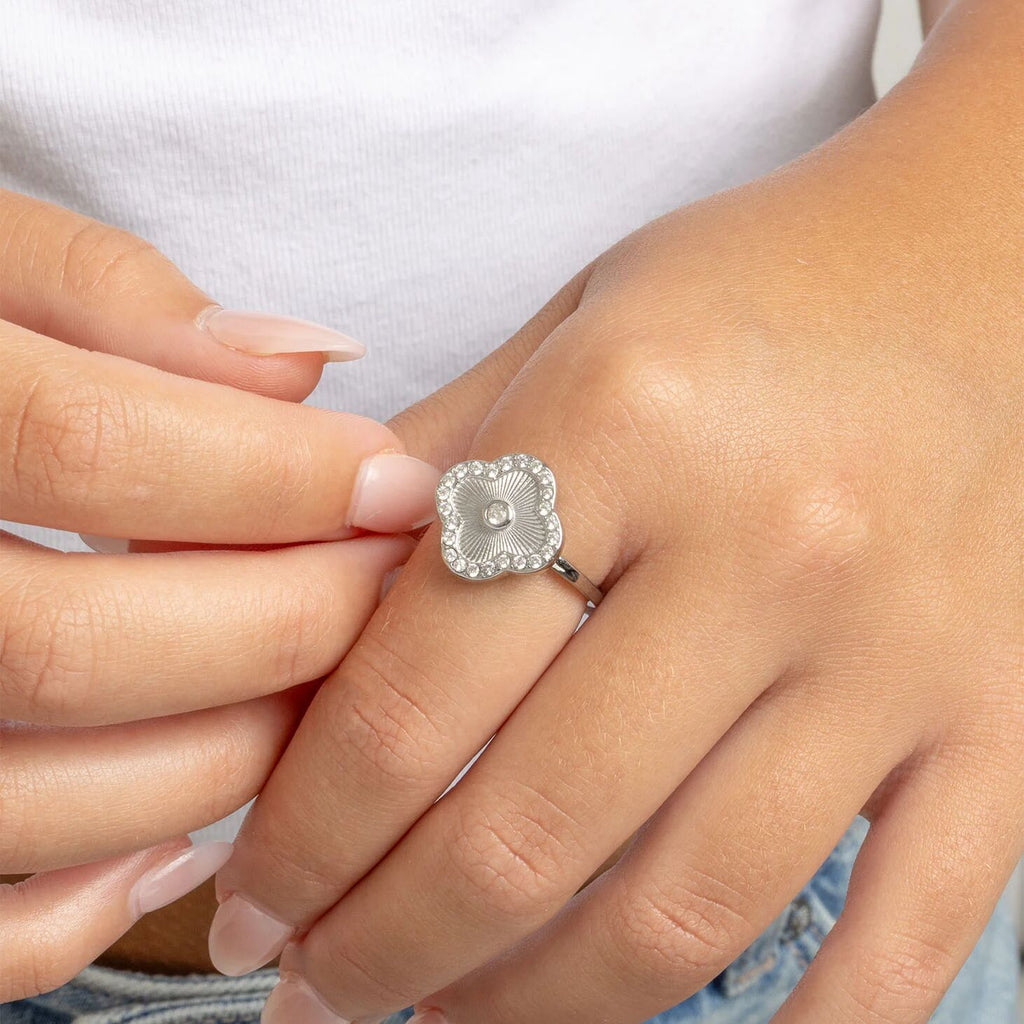 Hand wearing silver floral motif stacking ring