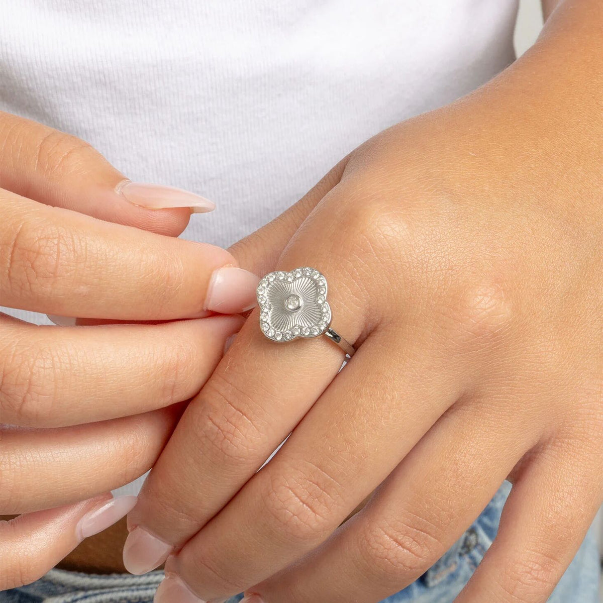 Hand wearing silver floral motif stacking ring