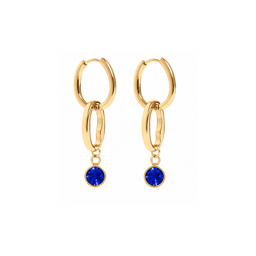 A pair of gold huggie hoop earrings with a double-ring design and a dangling round blue gemstone, shown on a plain white background.