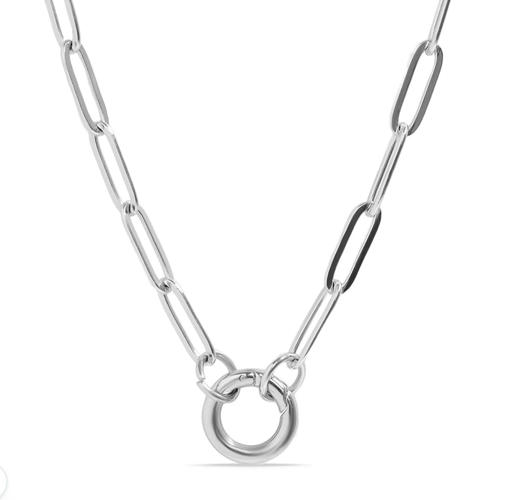 A silver paperclip chain necklace with a polished circular ring pendant, shown against a plain white background.