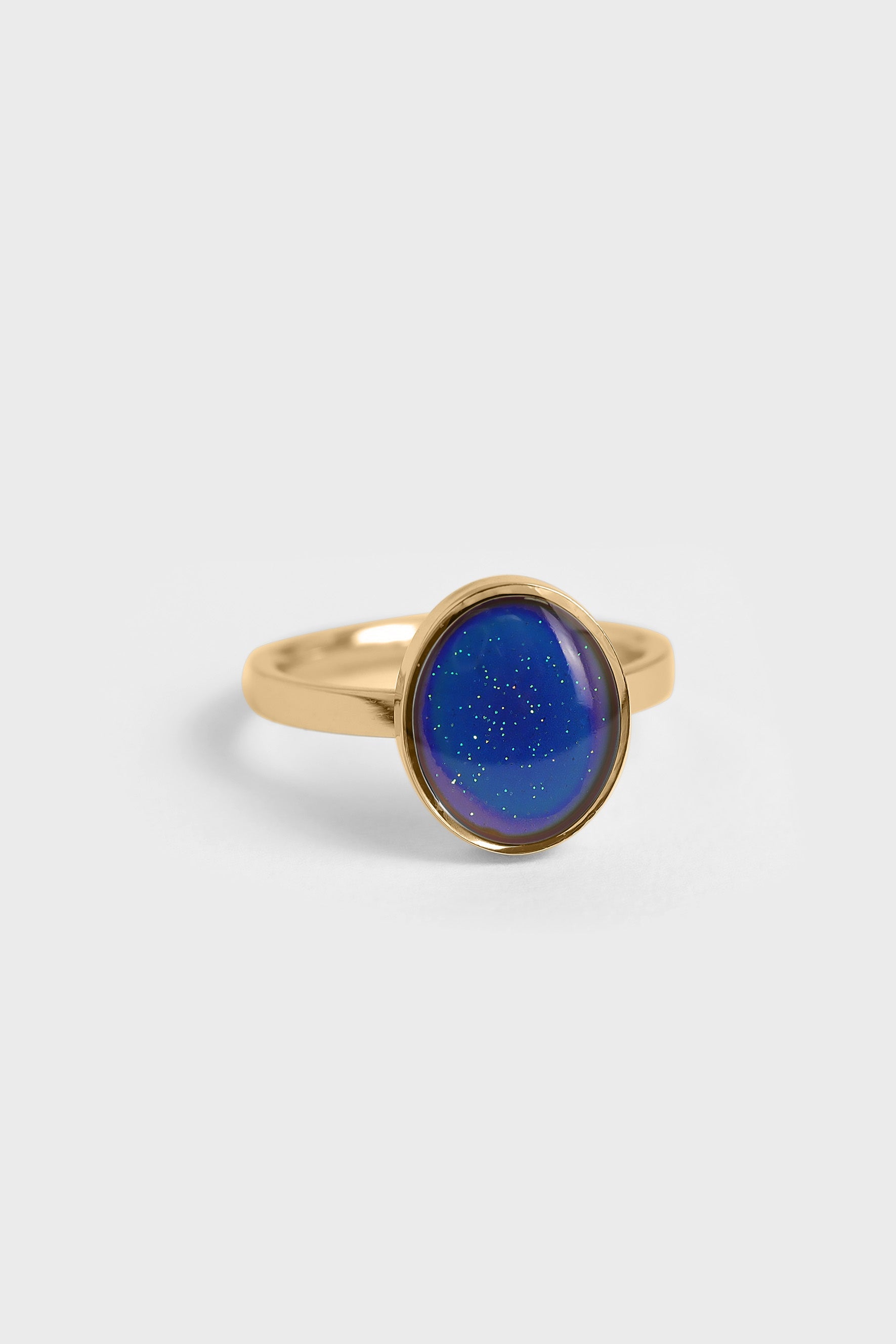 Gold mood ring with a blue gemstone on a white background
