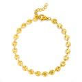 A gold chain bracelet made of small, round, textured disc links arranged in a circle, featuring a lobster clasp and extender chain, shown on a plain white background.