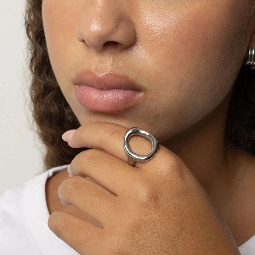 Close-up of a person wearing a silver ring on their finger.