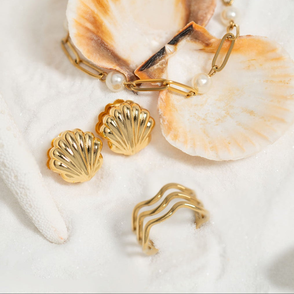 Gold shell-shaped jewelry set on seashells