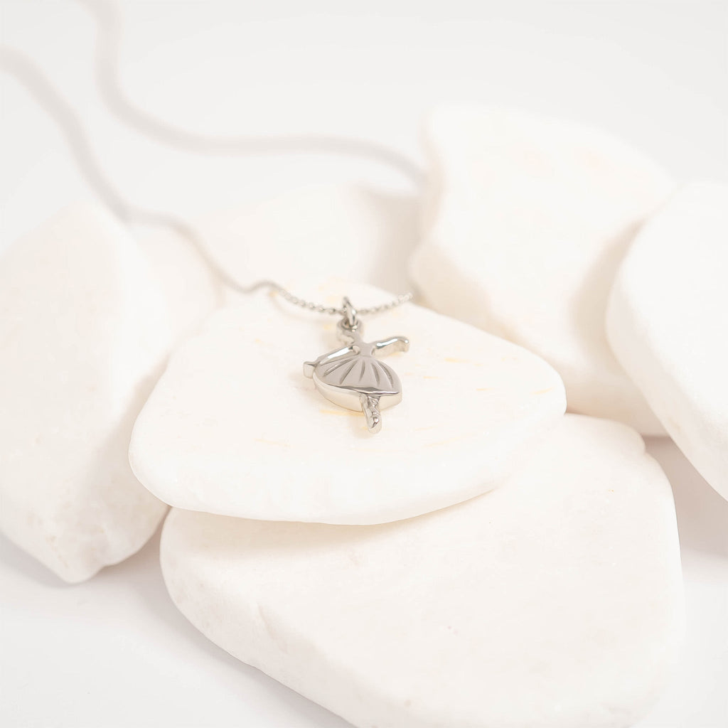 Silver necklace with a pendant on a white fabric background